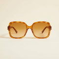 Aurore oversized retro sunglasses in honey tortoiseshell with amber lenses, against a cream studio backdrop