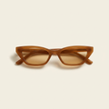 Colombe slim cat-eye sunglasses in caramel brown with amber lenses, against a cream studio backdrop
