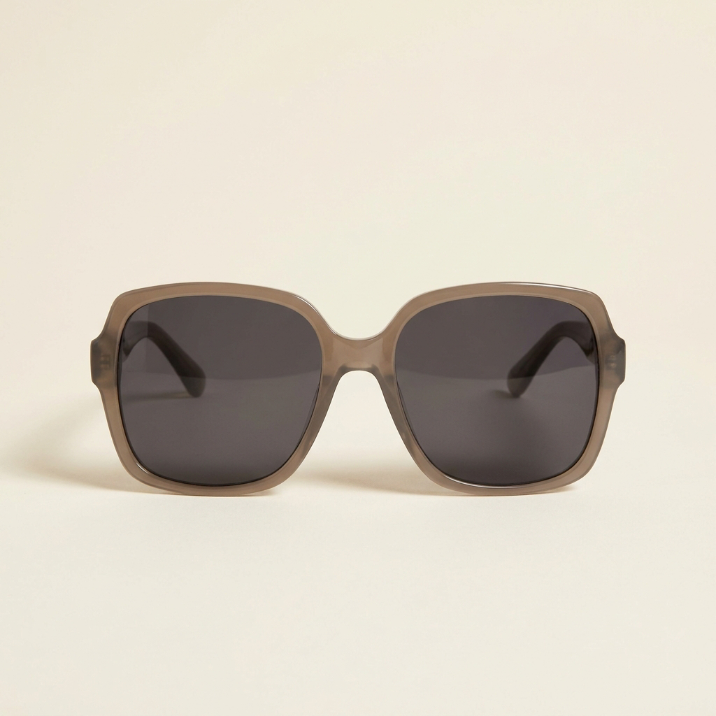 Fleur oversized polarised sunglasses in taupe grey with smoke lenses, against a cream studio backdrop