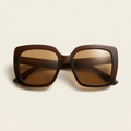 Roxane oversized wide-lens sunglasses in chocolate brown with bronze lenses, against a cream studio backdrop